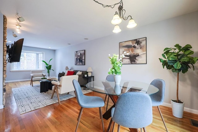 dining area with a chandelier and light hardwood / wood-style floors