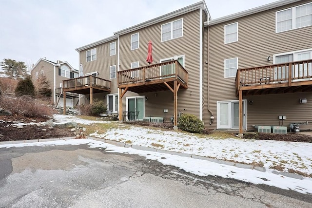 snow covered back of property with a balcony