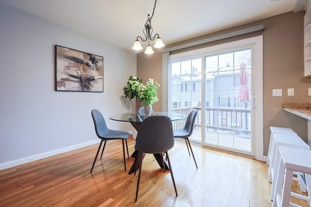 dining space featuring light hardwood / wood-style flooring and a chandelier