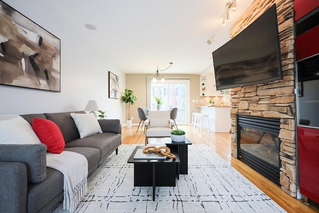 living room featuring a fireplace, track lighting, and light hardwood / wood-style flooring