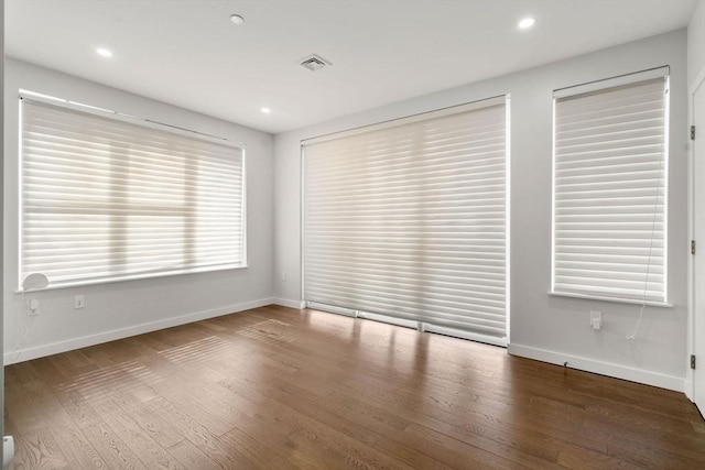 spare room with visible vents, recessed lighting, baseboards, and wood finished floors