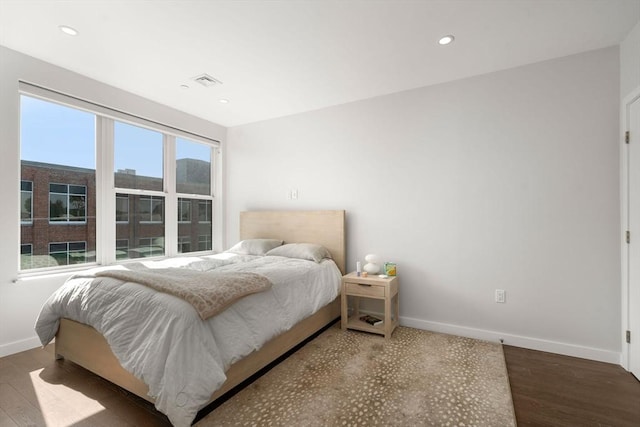 bedroom featuring wood finished floors, recessed lighting, baseboards, and visible vents