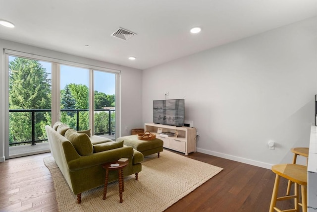 living area featuring visible vents, recessed lighting, baseboards, and wood finished floors