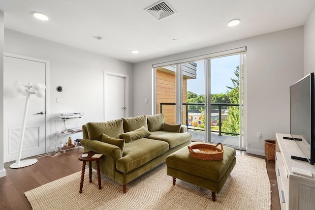 living room with recessed lighting, visible vents, baseboards, and wood finished floors