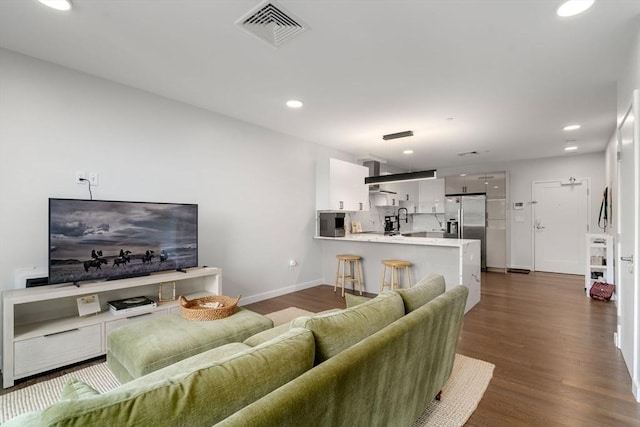 living room with dark wood-type flooring, recessed lighting, visible vents, and baseboards