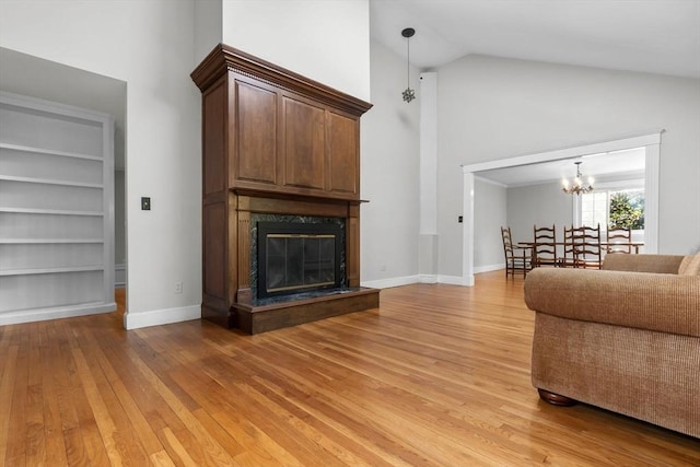 17 Topsfield Rd, Wenham, MA 01984 - living area featuring light wood finished floors, high vaulted ceiling, a chandelier, a premium fireplace, and baseboards