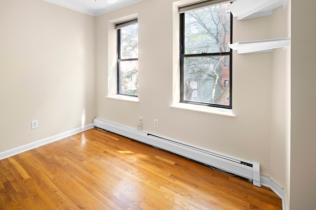 empty room featuring crown molding, light hardwood / wood-style flooring, and baseboard heating