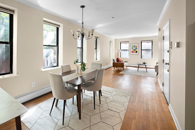 dining space featuring crown molding, plenty of natural light, baseboard heating, and light hardwood / wood-style flooring