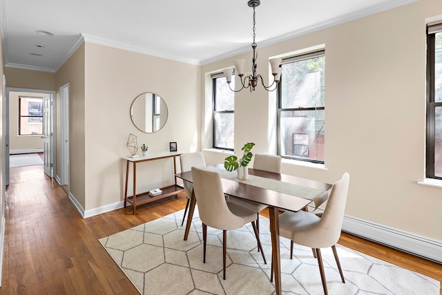 dining area featuring a baseboard radiator, ornamental molding, hardwood / wood-style floors, and a chandelier