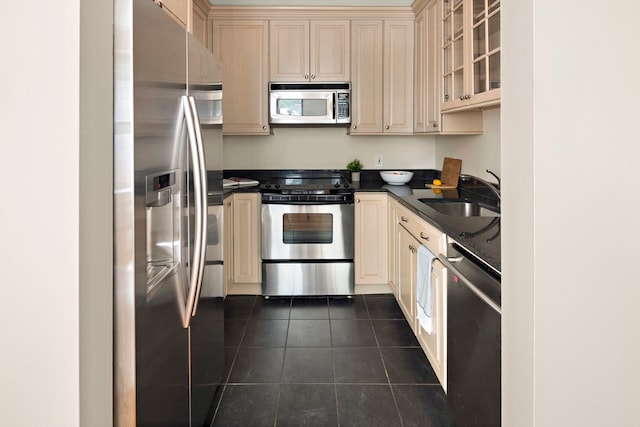 kitchen featuring dark tile patterned flooring, stainless steel appliances, and sink