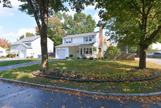 view of front facade with a front yard, a porch, and a garage