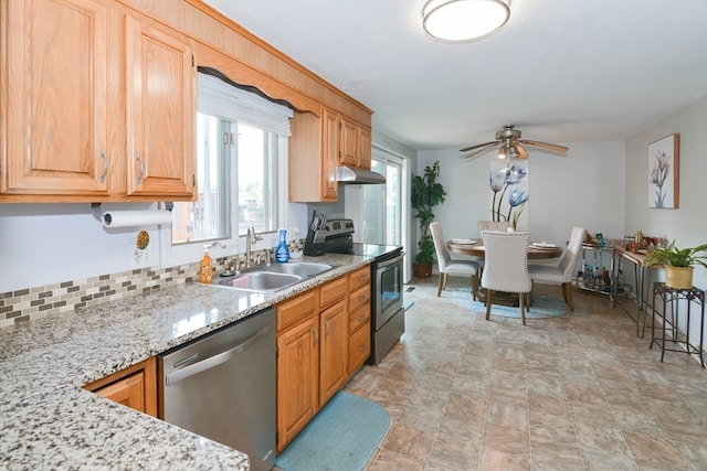 kitchen with sink, tasteful backsplash, appliances with stainless steel finishes, light stone counters, and ceiling fan