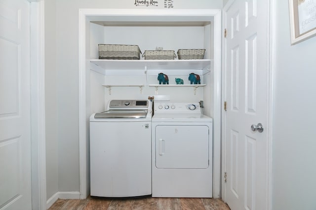 washroom with hardwood / wood-style flooring and washing machine and dryer