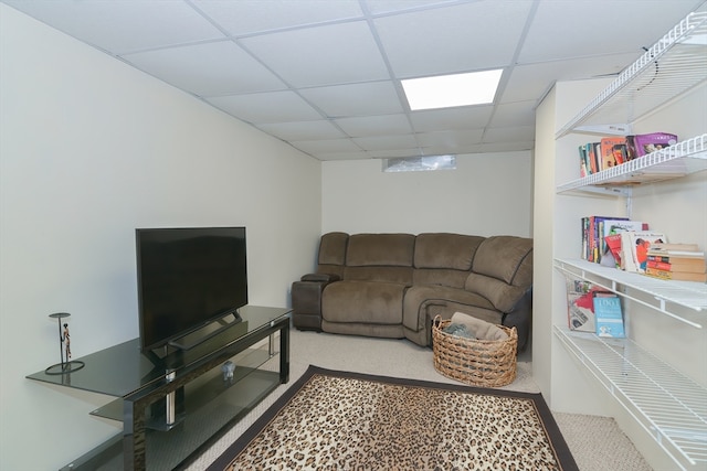 carpeted living room featuring a drop ceiling