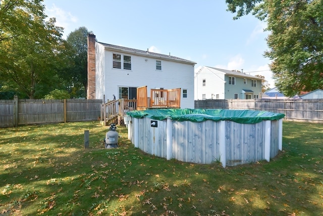 back of house with a pool side deck and a lawn