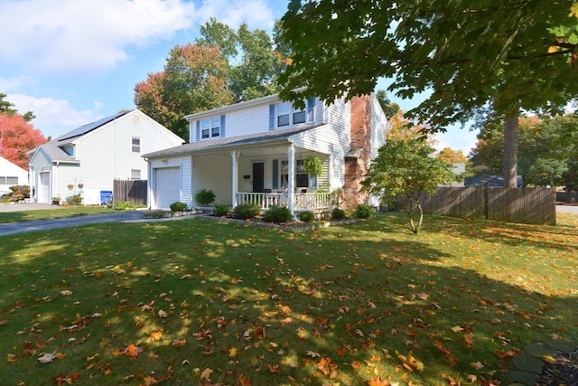 front of property with covered porch, a front yard, and a garage