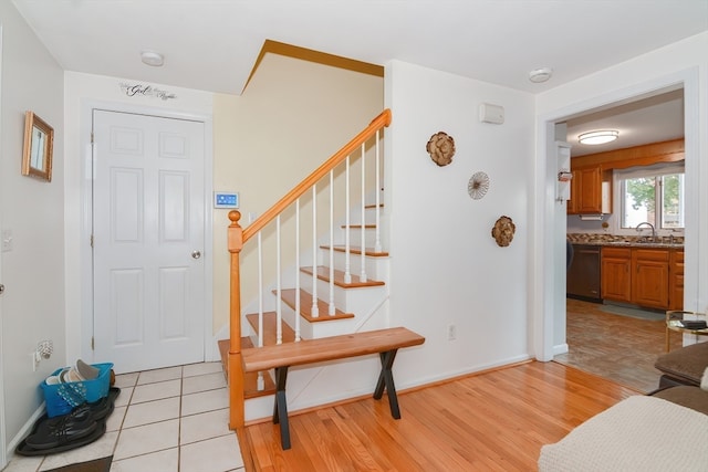 staircase with hardwood / wood-style flooring and sink