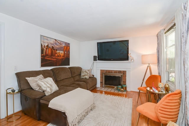 living room with a fireplace and light wood-type flooring