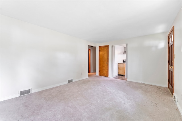 unfurnished bedroom featuring light colored carpet and ensuite bathroom