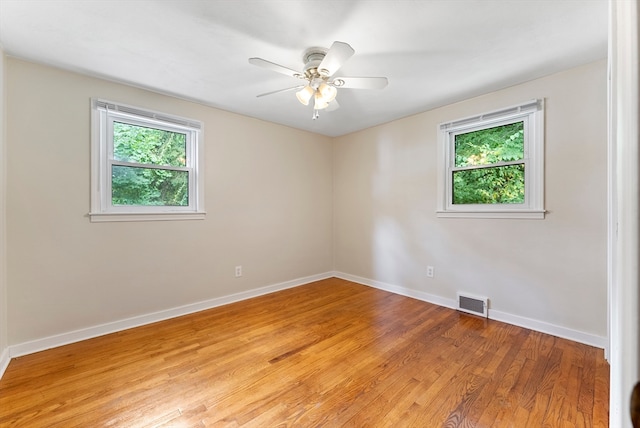 empty room with ceiling fan and hardwood / wood-style floors