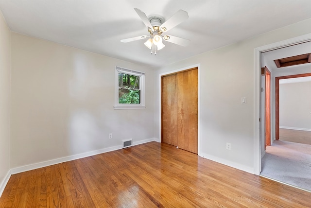 unfurnished bedroom with ceiling fan, a closet, and light wood-type flooring