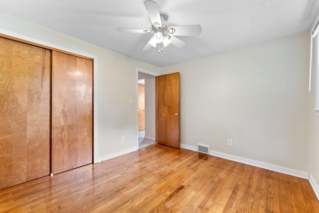 unfurnished bedroom with light hardwood / wood-style flooring, ceiling fan, and a closet