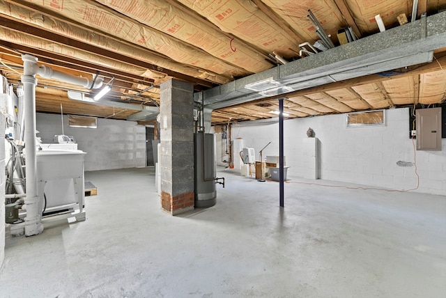 basement featuring electric panel, washing machine and dryer, and water heater