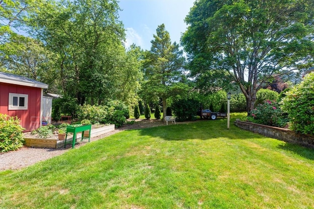 128 S Sea Ave, Yarmouth, MA 02673 - view of grassy yard featuring a storage unit and a garden
