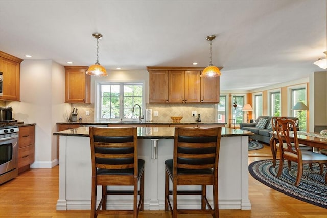 128 S Sea Ave, Yarmouth, MA 02673 - kitchen featuring stainless steel range with electric stovetop, open floor plan, decorative backsplash, recessed lighting, and dark stone counters