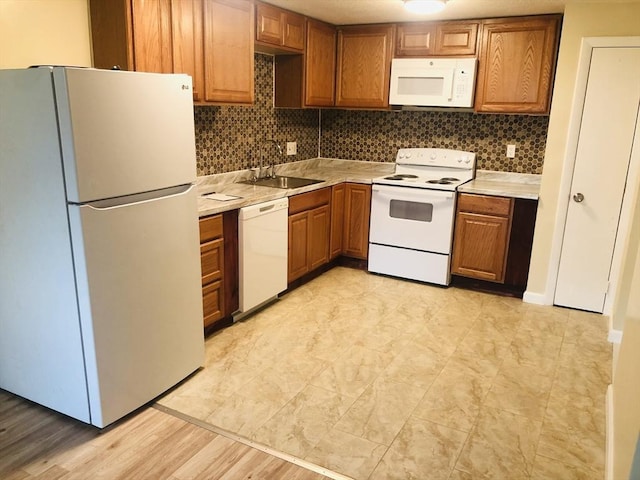 kitchen with sink, backsplash, and white appliances