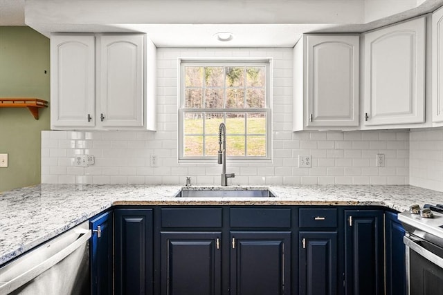 kitchen with a sink, white cabinetry, backsplash, blue cabinetry, and appliances with stainless steel finishes