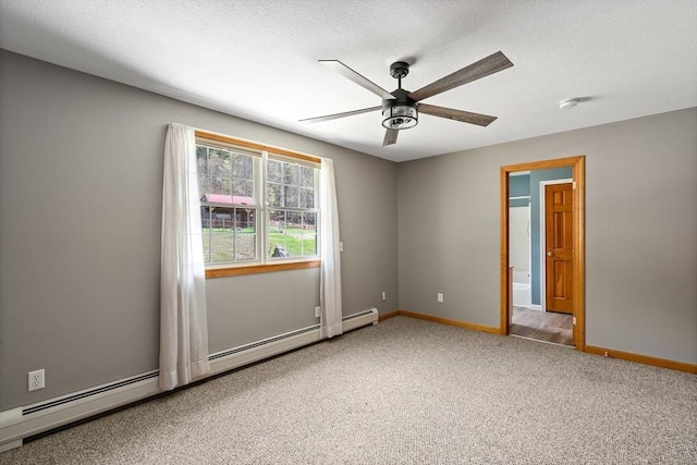 carpeted spare room with baseboard heating, a textured ceiling, baseboards, and a ceiling fan