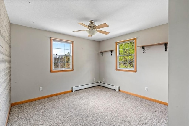 unfurnished room featuring a ceiling fan, baseboards, baseboard heating, and carpet
