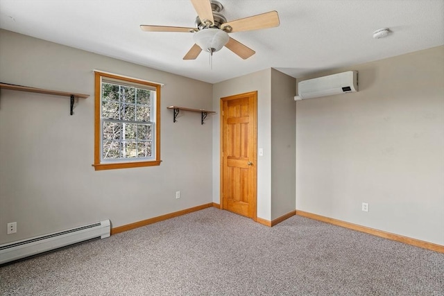 empty room with a baseboard radiator, a wall unit AC, baseboards, ceiling fan, and carpet floors