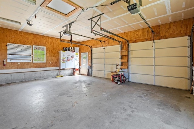 garage featuring wood walls and a garage door opener