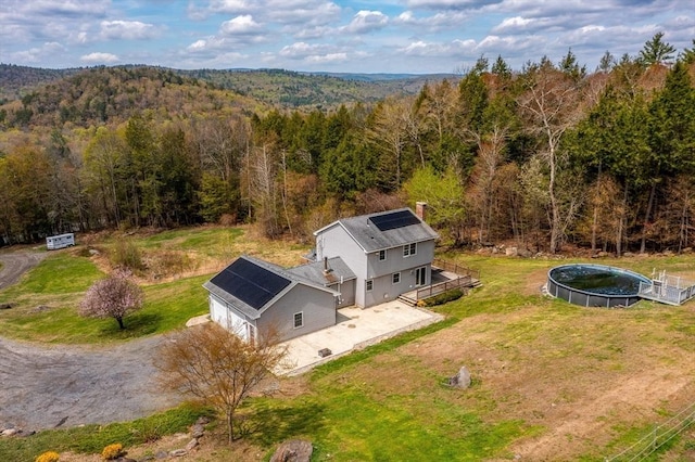 birds eye view of property featuring a forest view