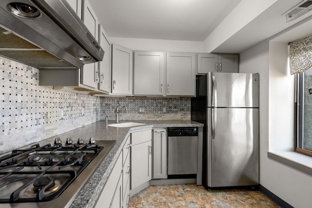 kitchen with visible vents, a sink, under cabinet range hood, appliances with stainless steel finishes, and decorative backsplash