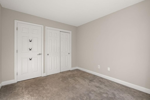 unfurnished bedroom with carpet flooring, baseboards, and a closet