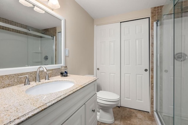 bathroom featuring vanity, toilet, a stall shower, and tile patterned flooring