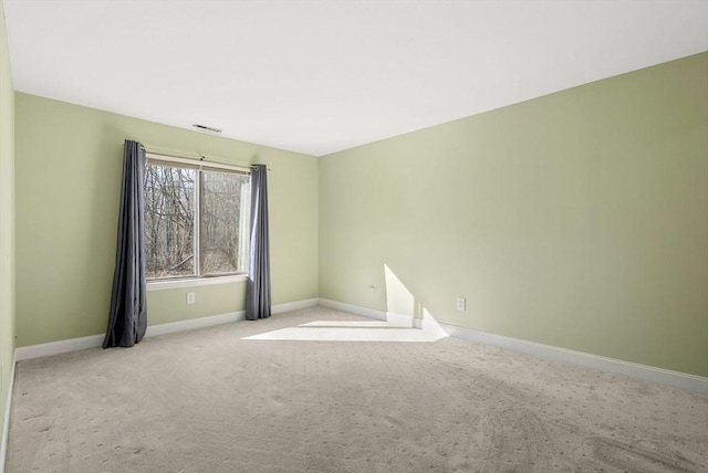 carpeted spare room featuring visible vents and baseboards