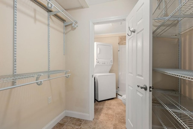 spacious closet with light tile patterned floors and stacked washer / drying machine