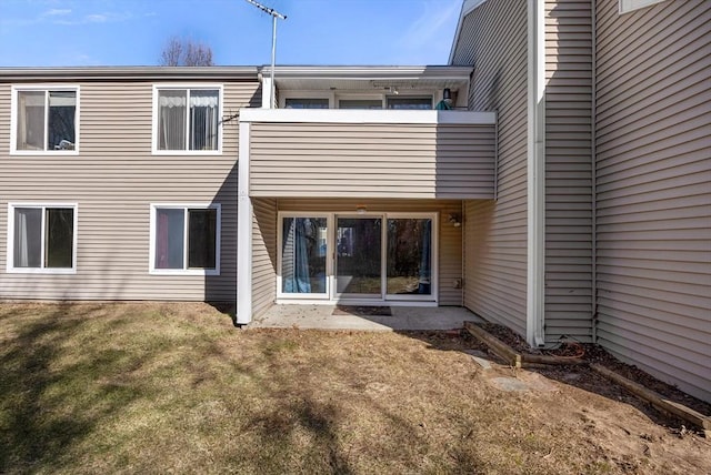 rear view of property with a balcony and a lawn