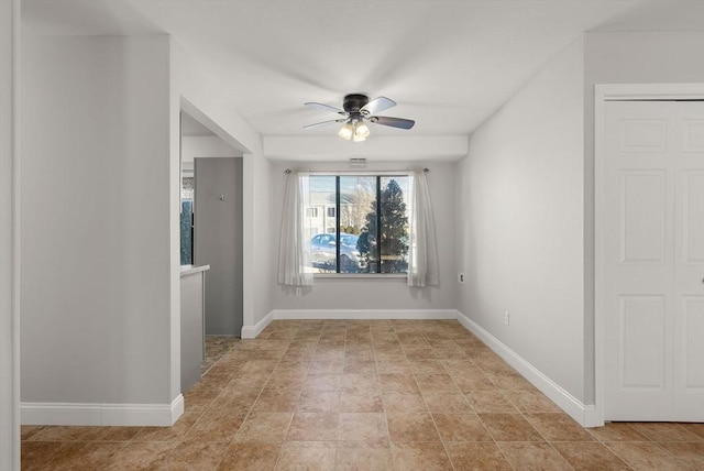 unfurnished room featuring baseboards and ceiling fan