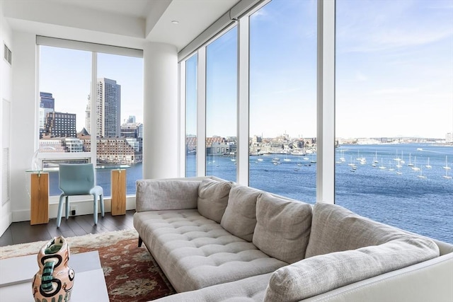 living area with a city view, a water view, visible vents, and wood finished floors