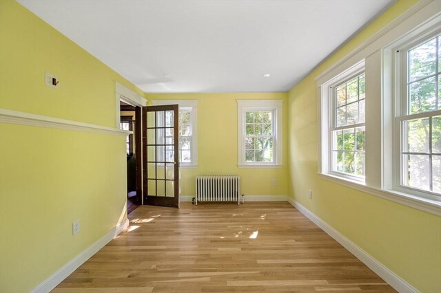 21 Otis St, Milton, MA 02186 - unfurnished room featuring radiator heating unit, baseboards, and light wood-style floors