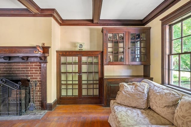 21 Otis St, Milton, MA 02186 - living room featuring plenty of natural light, beam ceiling, ornamental molding, hardwood / wood-style floors, and a fireplace