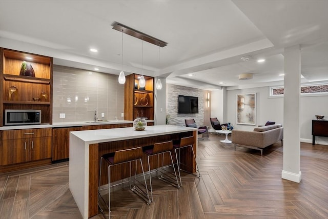 bar featuring pendant lighting, dark parquet flooring, sink, and tasteful backsplash