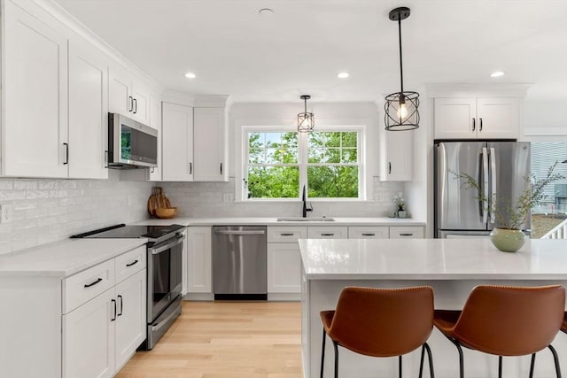 10 Sylvan Hill Xing, Haverhill, MA 01832 - kitchen featuring appliances with stainless steel finishes, a sink, light countertops, white cabinetry, and a breakfast bar