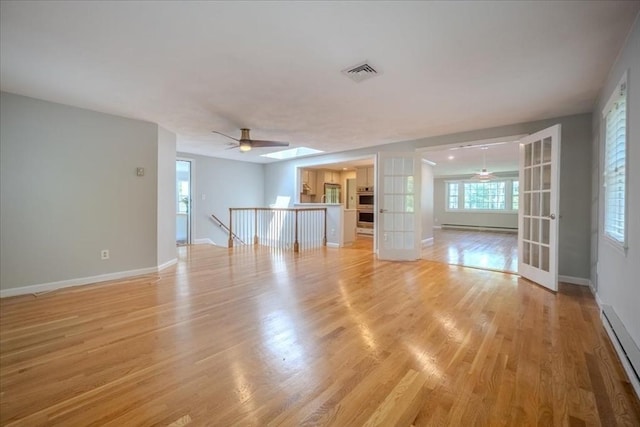 137 Naugler Ave, Marlborough, MA 01752 - unfurnished living room with a baseboard radiator, french doors, baseboard heating, and light wood-style floors