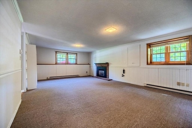 137 Naugler Ave, Marlborough, MA 01752 - unfurnished living room with a baseboard heating unit, a textured ceiling, carpet floors, a brick fireplace, and wainscoting